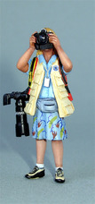 Femme photographe avec appareils en bandoulière, en position prise de vue